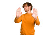 © Asier - Young caucasian man isolated on green chroma background standing with outstretched hand showing stop sign, preventing you.
