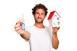 © Asier - Young caucasian man holding home keys and house model isolated