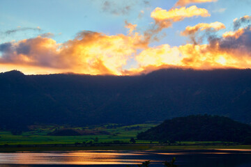 Wall Mural - lake at sunset with mountains in the background, cloudscape and yellow sunshines, in volcano crater of tepetiltic nayarit 