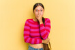 Young Asian woman isolated on yellow background scared and afraid.