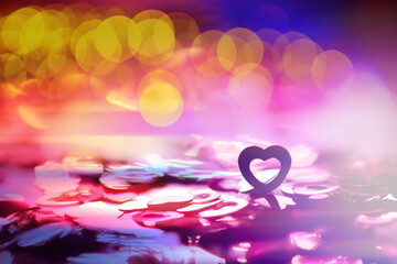 Wall Mural - Abstract colored background. Red toy in the shape of a heart on a glitter and bokeh background.