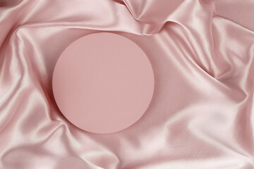 Wall Mural - Geometric round platform podium on pale pink silk satin background. Blank minimal cylinder form mock up background for cosmetic product presentation. Top view