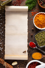 Wall Mural - Variety of spices and herbs with cookbook paper at table background