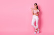 © deagreez - Full length photo of gorgeous cheerful lady indicate thumb finger empty space blank isolated on pink color background