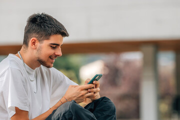young man looking at mobile phone in the street