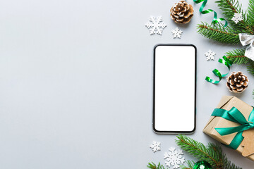 Wall Mural - Digital phone mock up with rustic Christmas decorations for app presentation top view with empty space for you design. Christmas online shopping concept. Tablet with copy space on colored background