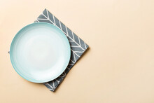 Top View On Colored Background Empty Round Blue Plate On Tablecloth For Food. Empty Dish On Napkin With Space For Your Design