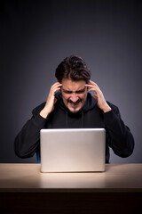 Wall Mural - Young male hacker on grey background