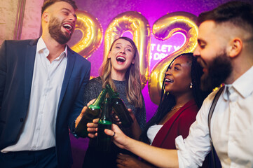 Multiracial people toasting drinks while celebrating in the club