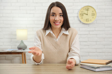 Canvas Print - Young businesswoman conducting webinar at desk in room