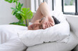 © kaew6566 - Fatigue asian man sleeping on white pillow with green tree beside window in morning. Tired pressure asian guy holding hand facepalm worry problem something sleepy headache on bed at home. Lifestyle.