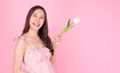 © kaew6566 - Satisfied excited asian woman holding tulips pointing up wonder to copy space smiling with toothy standing over isolated pink background. Cheerful young girl use tulips flower pointing present product