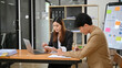© bongkarn - Professional Asian businesswoman focused on her tasks, working with her male colleague