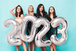 © halayalex - Beautiful women celebrating New Year. Happy gorgeous female in stylish sexy party dresses holding silver 2023 balloons, having fun at New Year's Eve Party. holiday celebration. Charming models