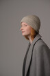 © Юрий Горид - young girl model in beige hipster hat and coat isolated on light background. Product photo mockup for fashion brands and marketplaces, woolen cap, turkish textiles.