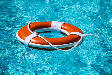 Lifebuoy in swimming pool. Summer vacation concept. Life buoy in water. Help concept.