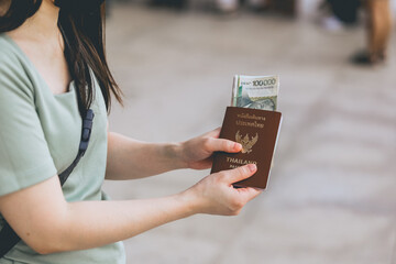 asian women with laos money and Thai passport in Tourist hand