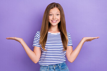 Wall Mural - Photo of positive cheerful girl dressed striped t-shirt compare products demonstrating empty space isolated on purple color background