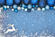 Christmas Eve North Pole Concept With Silver Reindeer And Sparkling Blue Bauble Decorations On Grunge Background. Festive Fun Magical Border For The Holiday Season. 