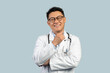Happy pensive middle aged chinese male doctor in white coat, glasses look at camera