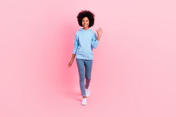 Canvas Print - Full length photo of cheerful positive person walking arm palm waving hi isolated on pink color background