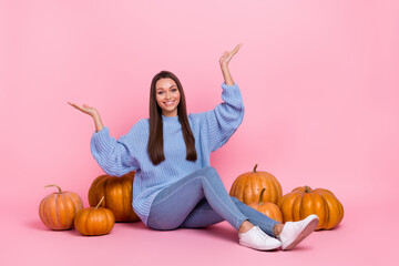 Sticker - Full body photo of sweet millennial brunette lady sit with pumpkin wear sweater jeans sneakers isolated on pink background