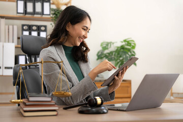 asian woman lawyer working and judge in a courtroom the gavel, working with tablet and laptop and di