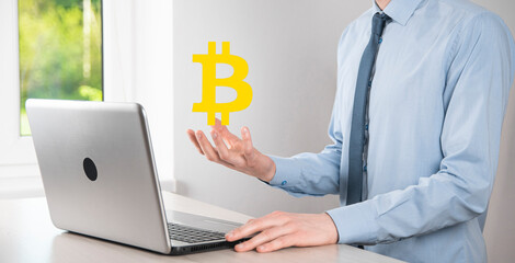 Male hand holding a bitcoin icon on blue background. Bitcoin Cryptocurrency Digital Bit Coin BTC Currency Technology Business Internet Concept.