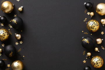 Wall Mural - Luxury Christmas background with gold and black baubles and confetti on dark table. Elegant Merry Christmas greeting card design, Happy New Year banner mockup