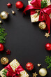 © photoguns - Christmas vertical banner. Frame made of gift boxes with red ribbon bow, fir branches, gold and red baubles on black background. Flat lay, top view, copy space.