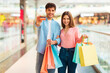 © Prostock-studio - Cheerful Spouses Showing Credit Card Holding Shopper Bags In Mall