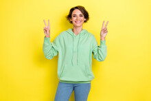 Photo Of Optimistic Nice Lovely Sweet Girl With Bob Hairstyle Wear Green Hoodie Jeans Showing V-sign Isolated On Yellow Color Background