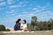 © Cala Serrano - Happy family spending time together at park. Family happiness love concept. Multi-ethnic couple with newborn baby enjoy fantastic day outdoor together. colorful blue sky as background. Family portrait
