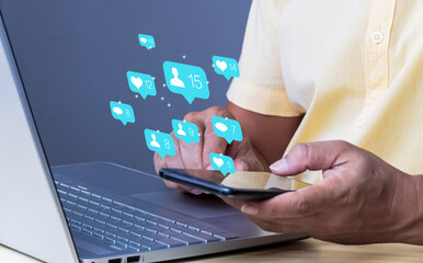 Wall Mural - man using smartphone and laptop with social media icons social media concept in daily life