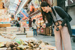 © PR Image Factory - excited asian female traveler finger pointing at fresh shellfish on display at a local stall selling seafood in kuromon ichiba market in Osaka japan