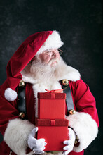 Santa Claus Looks To Side While Holding Gift Boxes