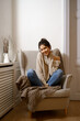 © arthurhidden - Smiling lady in smart trendy wear is sitting on armchair. Smiling, sitting in relaxing atmosphere indoors at home, nice design. Comfort and cozy girlish time