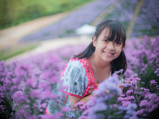 Wall Mural - A brightly smiling girl in native dress stands in a field of margarets