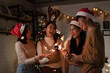 © DJ Creative Studio - Group of asian friends celebrating christmas party or new year with bengal lights. Friends having fun together at home party.