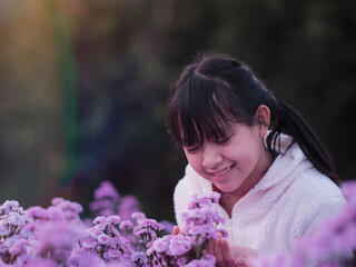 Wall Mural - A brightly smiling girl in native dress stands in a field of margarets flowers