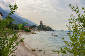 Wall Mural - View from the beach to the castle of old town Malcesine with ancient tower and fortress at Garda lake, Veneto region, Italy.