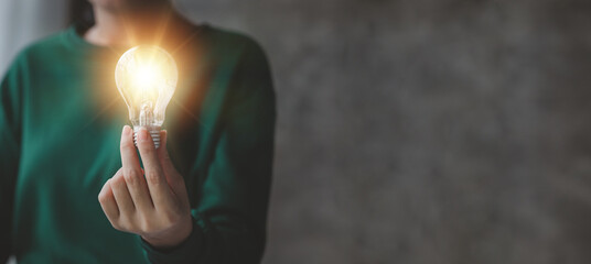 Woman holding glowing lamp, Creative new idea. Innovation, brainstorming, strategizing to make the business grow and be profitable. Concept execution, strategy planning and profit management.