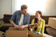 © ivanko80 - Smiling couple unpaking boxes in new home