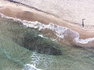 Wall Mural - Aerial view of a man by the sea in Platamona