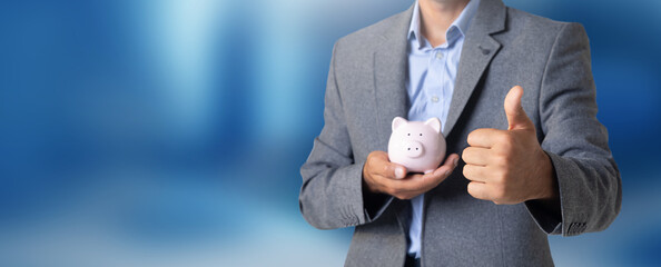 Wall Mural - Man holding a piggy bank in his hand