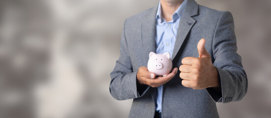 Wall Mural - Man holding a piggy bank in his hand