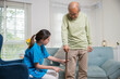 © sorapop - Asian doctor asking and explanation elderly man about pain symptom with walking stick, young woman nurse checking knee and leg after surgery of senior old man patient suffering from pain in knee