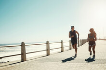 Fitness, Couple And Running For Exercise By Beach In Workout, Training And Cardio In South Africa Outdoors. Active Man And Woman In Sports Run By The Ocean In Sea Point For Healthy Exercising Outside