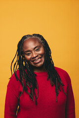 Wall Mural - Portrait of a happy mature woman smiling at the camera in a studio