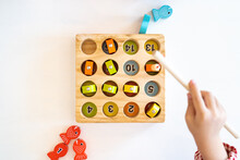 Topview, Flatlay Of Kid's Hands Are Playing And Finding The Matched Number In The Wooden Magnetic Fishing Game,